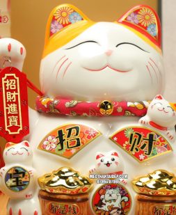 mèo thần tài vẫy tay cầm thẻ bài may mắn